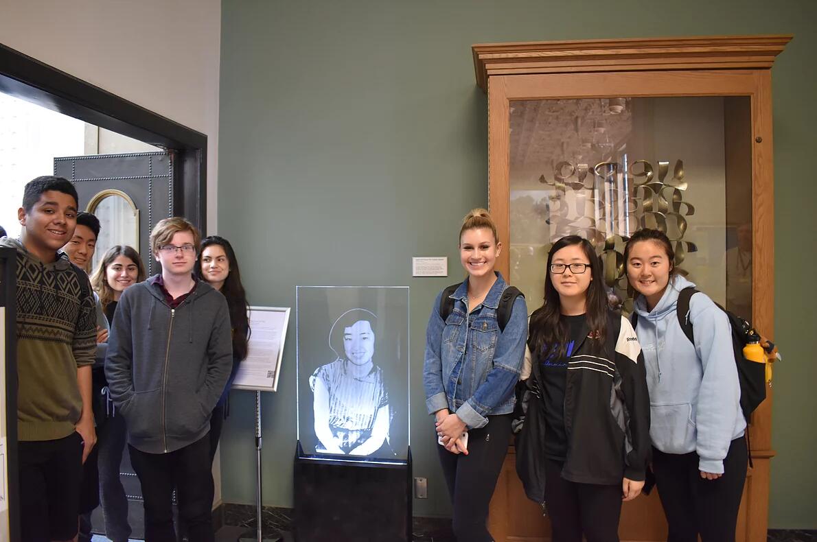 Students standing next to a figure of Yoshiko Uchida in Doe Library.