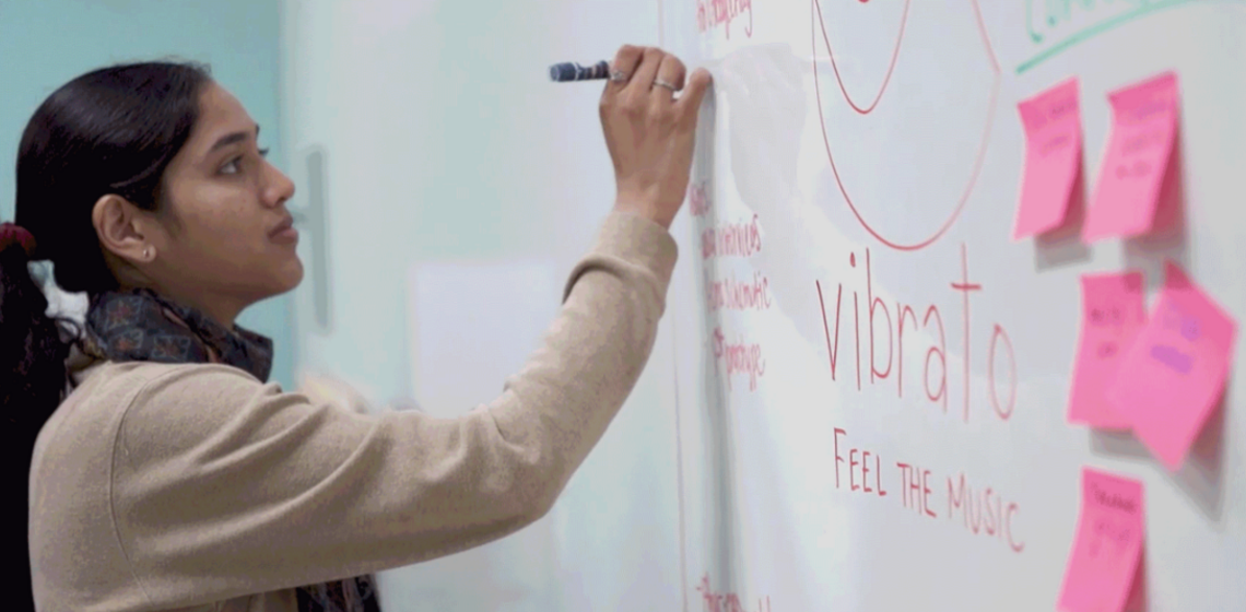 Student writing music theory notes on a whiteboard